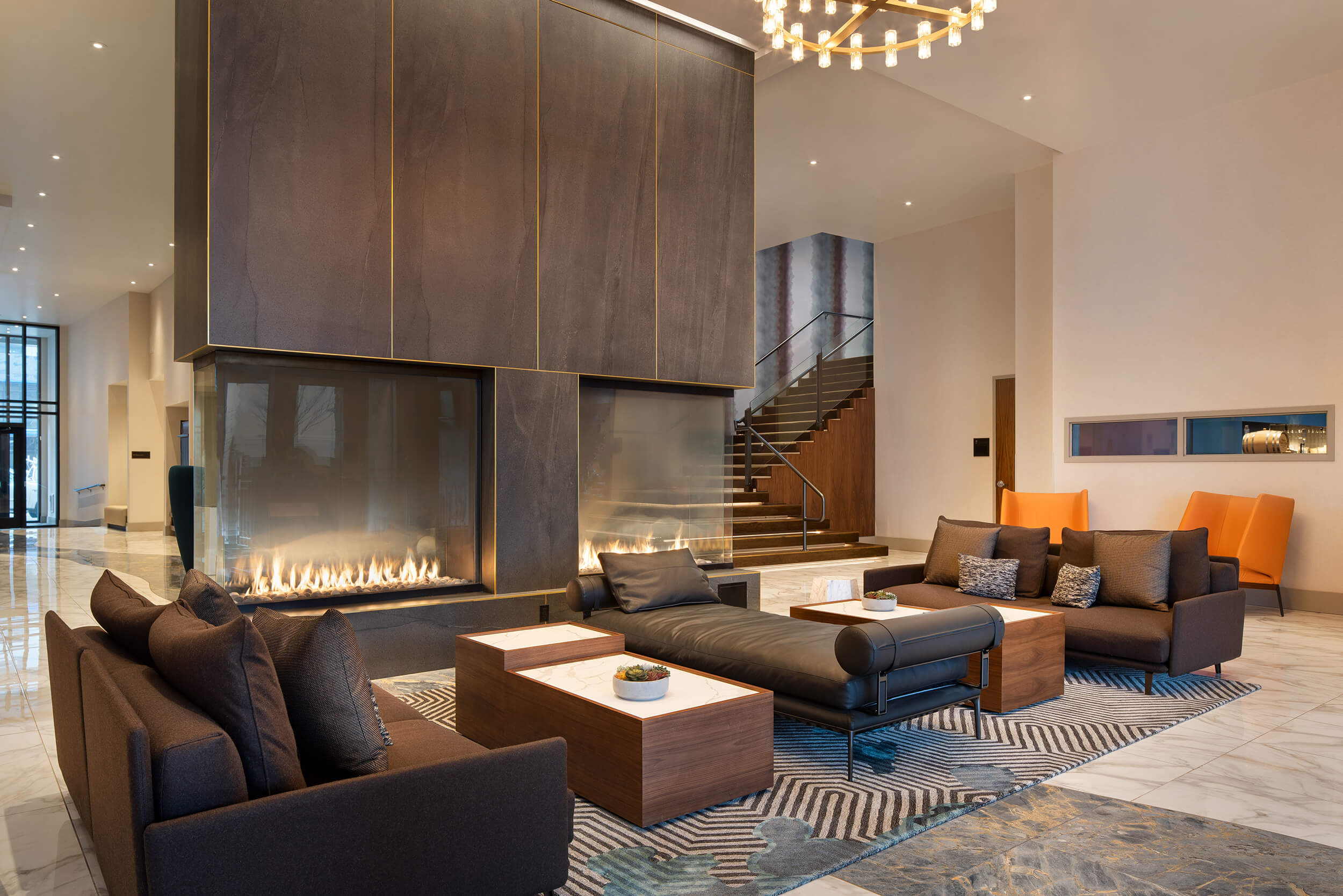 Lobby of the Hotel Indigo Hotel in Vancouver Washington, featuring soaring ceilings, fireplaces and ample leather seating.